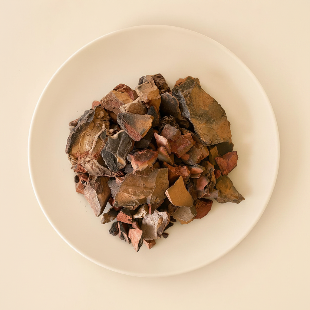 Red Diamond Clay chunks on a white ceramic plate, top-down view